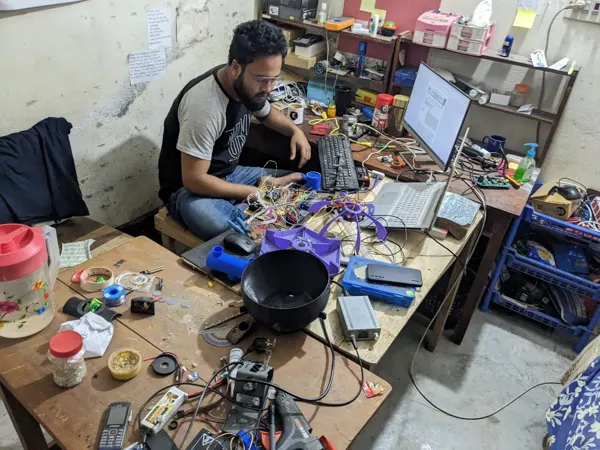 The feeder and its electronics spread across the room-lab workbench.