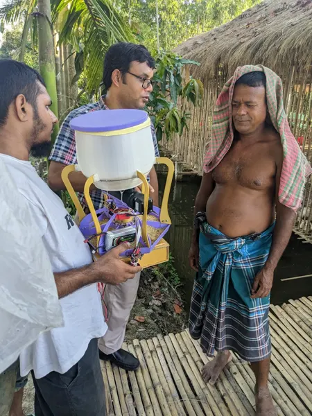 Discussing the feeder prototype during a farm visit.
