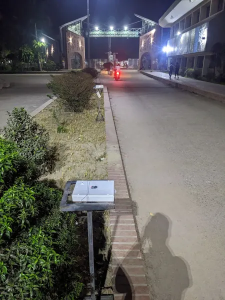 Lighting prototypes positioned along a campus road for night-time observation.