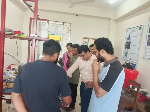 A group discussion around the shared laboratory workbench.