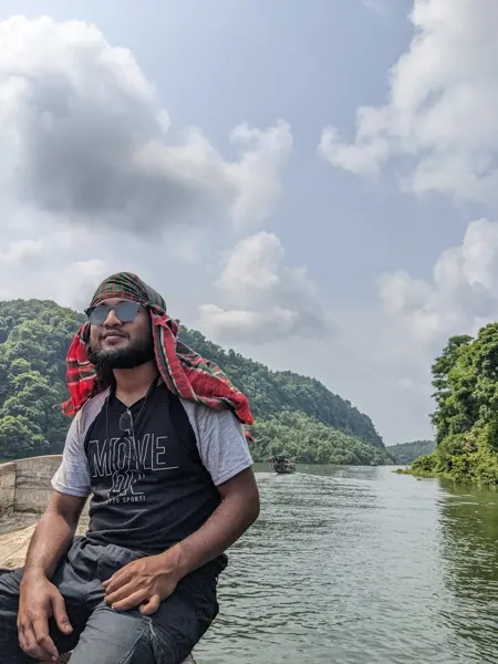 A boat journey with a river and wooded hills in the background.